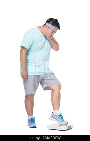 Obese young man weight measurement Stock Photo