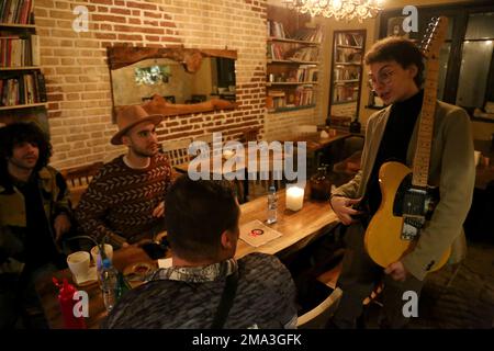 Tehran, Iran. 18th Jan, 2023. Iranian musician, Alin Joharchi (R), speaks with his friends after his music performance at a cafe in downtown Tehran. (Credit Image: © Rouzbeh Fouladi/ZUMA Press Wire) EDITORIAL USAGE ONLY! Not for Commercial USAGE! Stock Photo