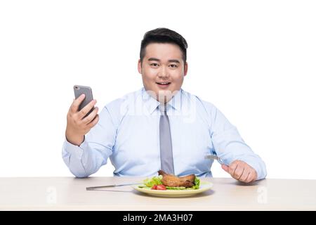 Fat people eat in with mobile phone Stock Photo