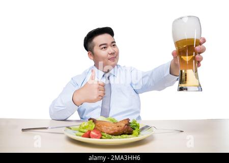 Fat man drinking beer at dinner Stock Photo