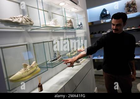 A store manager points out Yeezy shoes made by Adidas that are displayed inside cases at Addict shoe store in Brickell City Center in Miami Tuesday Oct. 25 2022. AP Photo Rebecca Blackwell Stock Photo...