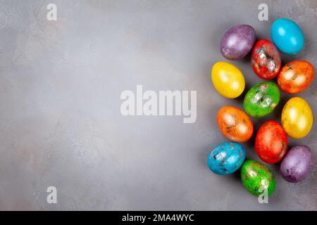 Easter concept wit colorful Easter eggs on grey background. Top view with copy space. Stock Photo