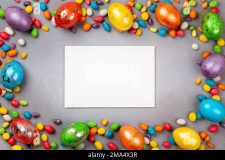 Colorful Easter eggs and chocolate Easter sweets  on grey background. Top view with copy space. Festive Easter concept. Stock Photo