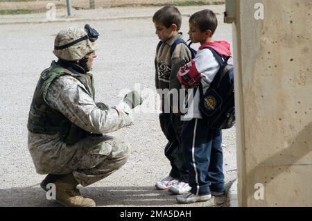 US Marine Corps (USMC) STAFF Sergeant (SSGT) Mouricio Mota from the 4th Civil Affairs Group (CAG) speaks to children during a Medical Assessment in Akashat, Iraq (IRQ), in support of Operation IRAQI FREEDOM. Subject Operation/Series: IRAQI FREEDOM Base: Ar Rutbar State: Al Anbar Country: Iraq (IRQ) Stock Photo