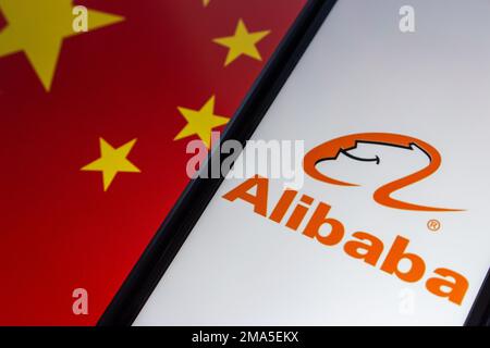 The logo of Alibaba seen in an iPhone on Chinese flag background ...