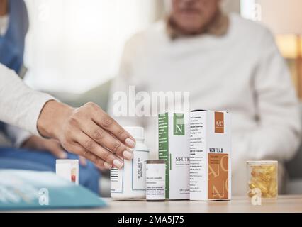 Healthcare workers are angels on earth. an unrecognizable nurse helping a patient with their medication during a checkup at home. Stock Photo