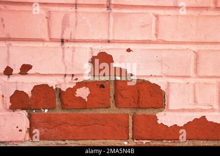 Peeling red paint on brick wall, background or texture Stock Photo