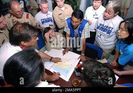 050206-N-1450G-052. [Complete] Scene Caption: Dr. Robin Nandy (blue vest) of the Centers for Disease Control (CDC) and Prevention, explains current conditions in Banda Aceh on the island of Sumatra, Indonesia, to a group of health care providers from Project HOPE (a civilian organization of medical volunteers) and US Navy medical personnel aboard the Military Sealift Command (MSC) Hospital Ship USNS MERCY (T-AH 19). Dr. Nandy, SENIOR Service Fellow working in the Global Immunization Division, is helping organize immunizations in Banda Aceh and the surrounding areas. The MERCY is currently off Stock Photo