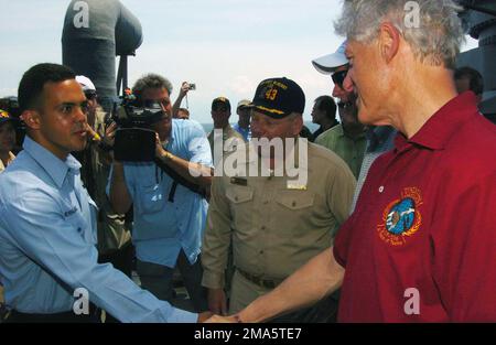 050220-N-5067K-018. [Complete] Scene Caption: Former US President William J. Clinton shakes the hand of US Navy (USN) SEAMAN (SN) Yandy Hernandez as he congratulates him aboard the Whidbey Island Class Amphibious Dock Landing Ship USS FORT MCHENRY (LSD 43). USN SN Hernandez conducted more than 200 critical crane lifts for over 500,000 pounds of relief supplies during Operation UNIFIED ASSISTANCE. USN Sailors and US Marine Corps (USMC) Marines greeted former Presidents Clinton and George H. W. Bush as they toured various spaces aboard the ship receiving operational briefings on each sections pa Stock Photo