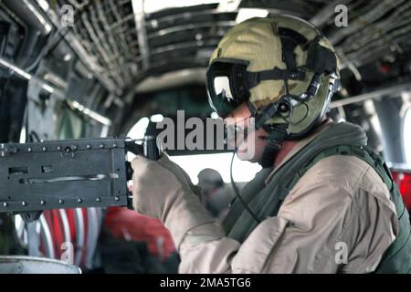 US Marine Corps (USMC) GUNNERY Sergeant (GYSGT) Brian T. Rogers, Aerial GUNNER and Maintenance Controller assigned to Marine Medium Helicopter Squadron One Six Five (HMM-165), 15th Marine Expeditionary Unit, Special Operations Capable (MEUSOC)), fires a.50 caliber machine gun from aboard a USMC CH-46 Sea Knight helicopter at a target during a live-fire exercise at the Udairi Range in Kuwait, during Operation IRAQI FREEDOM. Subject Operation/Series: IRAQI FREEDOM Base: Udairi Range Country: Kuwait (KWT) Stock Photo