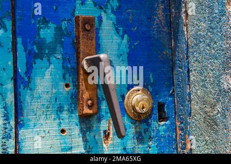 An old rusted doorknob with a lock on an old blue door, Cape Verde Islands, Africa Stock Photo