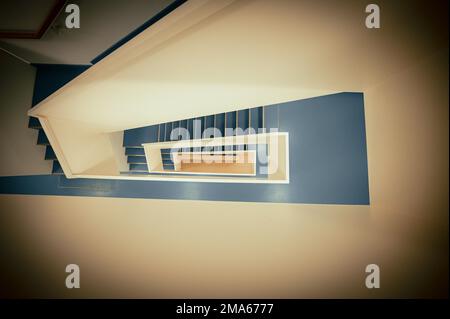 Staircase with white banister and blue vinyl floor from top to bottom, Jena Thuringia, Germany Stock Photo