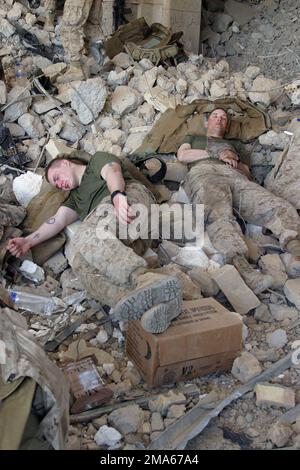 US Marine Corps (USMC) Marines assigned to Bravo Company, 1ST Battalion, 6th Marines, rest amid the rubble of a destroyed building during a weapons sweep across the Thar Thar Lake area in Iraq, during Operation Khanjar. The USMC 2d Marine Division and members of the Multi-National Force West (MNF-W) are conducting counter-insurgency operations with Iraqi Security Forces (ISF) to isolate and neutralize Anti-Iraqi Forces, in support of Operation IRAQI FREEDOM. Subject Operation/Series: IRAQI FREEDOM Base: Tar Tar Lake Country: Iraq (IRQ) Stock Photo