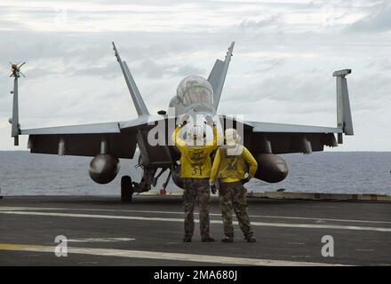 050622-N-8604L-065. [Complete] Scene Caption: US Navy (USN) aircraft directors signal for an USN F/A-18F Super Hornet, Strike Fighter Squadron 102 (VFA-102), Diamondbacks, Naval Air Facility (NAF) Atsugi, Japan (JPN), to taxi to one of four steam-powered catapults on the flight deck aboard the USN Aircraft Carrier USS KITTY HAWK (CV 63). The KITTY HAWK is currently operating in the Coral Sea in support of Exercise TALISMAN SABRE 2005. TALISMAN SABRE is an exercise jointly sponsored by the US Pacific Command (USPACOM) and Australian Defense Force Joint Operations Command, and designed to train Stock Photo