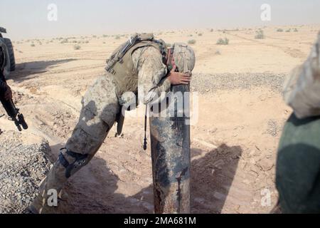 US Marine Corps (USMC) Second Lieutenant (2LT) Chisolm assigned to Bravo Company, 1ST Battalion, 6th Marines, looks down a pipe to see if there is an underground base there during Operation Dagger, conducted in the Lake Thar Thar area in Iraq. The USMC 2d Marine Division and members of the Multi-National Force West (MNF-W) are conducting counter-insurgency operations with Iraqi Security Forces (ISF) to isolate and neutralize Anti-Iraqi Forces, in support of Operation IRAQI FREEDOM. Subject Operation/Series: IRAQI FREEDOM Base: Thar That Lake Country: Iraq (IRQ) Stock Photo