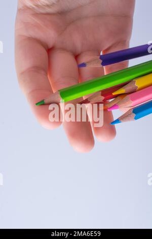 Hand holding color Pencils placed on a white background Stock Photo