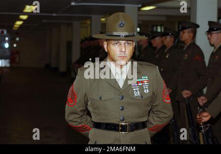 US Marine Corps (USMC) SENIOR Drill Instructor (DI) STAFF Sergeant (SSGT) T. Warren, Platoon (PLT) 1057, Bravo Company (B CO), 1ST Recruit Training Battalion (RTB), stands at parade rest while waiting for the Battalion Commander aboard Marine Corps Recruit Depot (MCRD), Parris Island, South Carolina (SC). The Battalion Commander is inspecting the B CO recruits as they wrap up their final week of recruit training. Base: USMC Recruit Depot,Parris Island State: South Carolina (SC) Country: United States Of America (USA) Stock Photo