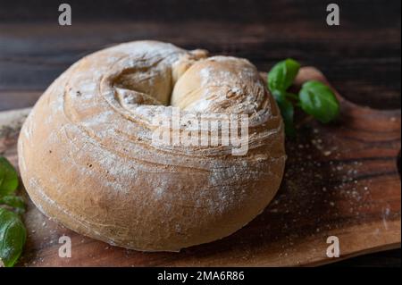 Round loaf of ciabatta bread on dark and rustic background. Closeup and front view Stock Photo