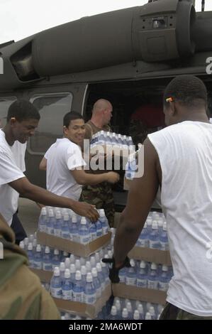 US Navy (USN) Sailors and Army National Guard (ARNG) personnel load relief water and ice into a ARNG UH-60 Blackhawk helicopter at Gulf Port International Airport in Biloxi, Mississippi (MS). Department of Defense (DoD) units are mobilized as part of Joint Task Force (JTF) Katrina to support the Federal Emergency Management Agency's (FEMA) disaster-relief efforts in the Gulf Coast areas devastated by Hurricane Katrina. (Duplicate image, see also DNSD0600770 or search 050901N0318R046)(A3597). Subject Operation/Series: KATRINA RELIEF Base: Biloxi State: Mississippi (MS) Country: United States Of Stock Photo