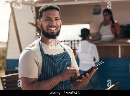 This tablet makes doing business easier. a young business owner using his digital tablet. Stock Photo