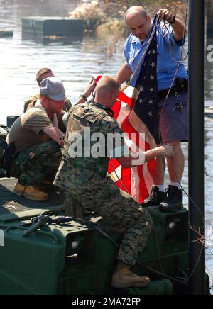 US Marine Corps (USMC) Marines prepare to hoist an American flag pulled out of floodwaters in New Orleans. The USMC Marines of 4th Assault Amphibian Battalion, along with 1ST Battalion, 8th Marine Regiment, are conducting search and rescue (SAR) missions throughout the New Orleans area in support of Joint Task Force Katrina. Base: New Orleans State: Louisiana (LA) Country: United States Of America (USA) Stock Photo