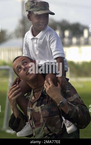 US Army (USA) Corporal (CPL) Chris George, Headquarters and Headquarters Battery (HHB), 1ST Battalion (BN), 201st Field Artillery (FA) Regiment, West Virginia Army National Guard (VWARNG), Fairmont, West Virginia (WV), gives a child, from New Orleans, a ride on his shoulders at the Houma-Terrbonne Civic Center in Houma, Louisiana (LA). The civic center is a temporary home for roughly 500 people evacuated from Terrbonne Parish and New Orleans as a result of Hurricanes Katrina and Rita. The US Army is contributing to the humanitarian assistance operations being led by the Federal Emergency Manag Stock Photo