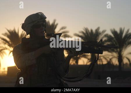 US Marine Corps (USMC) Lance Corporal (LCPL) Christopher Ahrens, 1ST Platoon (PN), Golf Company (G CO), 2nd Battalion (BN), 2nd Marines, uses the scope on his KAC 5.56 mm Modular Weapon System (MWS) SOPMOD (Special Operation Peculiar Modification) M4 rifle to scan the horizon during a security patrol in downtown Kharma, Iraq, during Operation IRAQI FREEDOM. Base: Fallujah State: Al Anbar Country: Iraq (IRQ) Stock Photo