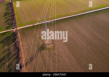 Aerial view of power lines on a high voltage pylon in a rural field Stock Photo