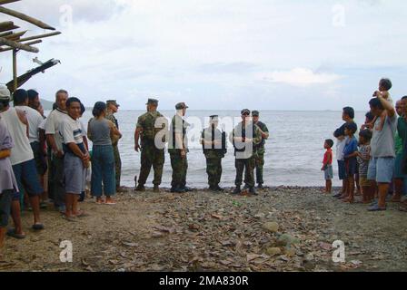 060221-N-4772B-189. [Complete] Scene Caption: US Navy (USN) Sailors, Beach MASTER Unit One (BMU-1) Detachment (DET), USS HARPERS FERRY (LSD 49), Forward Deployed Amphibious Ready Group (ARG), and local villagers wait on the shoreline, outside of Himbangan Village, Saint Bernard Municipality, Leyte Island, Philippines (PHL), for a LCU 1600 Class Utility Landing Craft to approach and offload supplies and personnel to assist with the rescue and recovery effort to find survivors after a landslide devastated Guinsahugon Village, Saint Bernard Municipality, Leyte Island, Philippines (PHL). The USS H Stock Photo