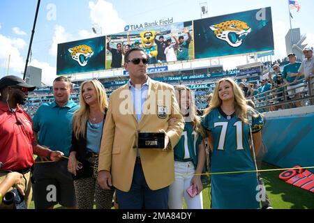 Former Jacksonville Jaguars offensive tackle Tony Boselli, right, stands  with owner Shahid Khan, center, as Pro Football Hall of Fame president Jim  Porter speaks during a ceremony where Boselli was presented with