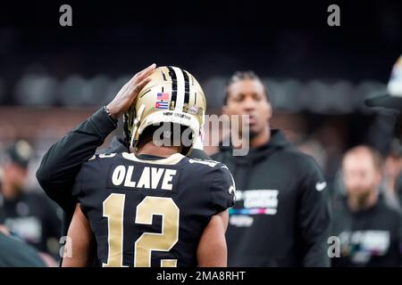 New Orleans Saints wide receiver Chris Olave wears his helmet showing an  American flag, Cuban flag and the Crucial Catch logo before an NFL football  game between the Saints and the Seattle