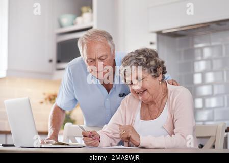 Our fling turned into a lifetime. an elderly couple going over paperwork at home. Stock Photo