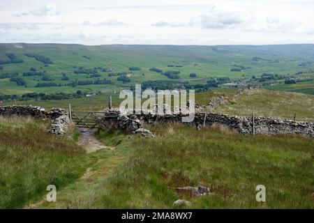 Looking Down on Hawes from a Dry Stone Wall and Gate above Gaudy Lane on the Pennine Way in  Wensleydale, Yorkshire Dales National Park, England, UK. Stock Photo