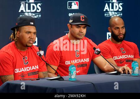 Cleveland Guardians' Amed Rosario, right, and Jose Ramirez, left, attend a  news conference with an interpreter before a workout ahead of Game 1 of  baseball's American League Division Series against the New