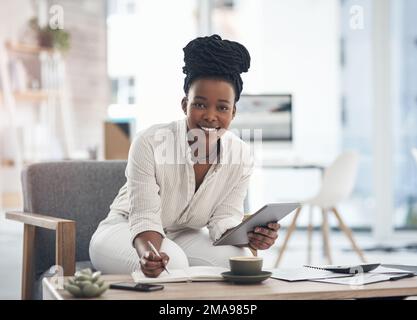 Making notes keeps me sharp. a businesswoman using her digital tablet while writing notes. Stock Photo