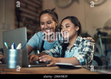 Id rather stay where I grow. two young workers using a laptop at work. Stock Photo