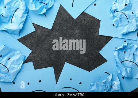 Blue crumpled sticky notes blank with drawing sad face on black background with copy space ready for your message. Blue Monday and mental health conce Stock Photo