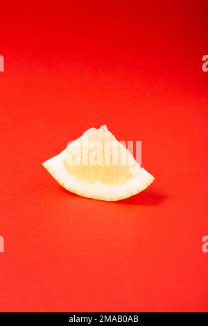 Photo of a piece of lemon isolated on a red background. Clipping path. Full depth of field. Stock Photo
