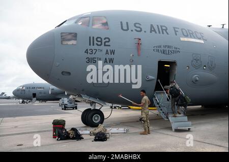 U.S. Air Force Staff Sgt. Dalton White, a C-17 Globemaster III loadmaster, steps onto his aircraft before an aerial refueling mission on Joint Base Charleston, SC, May 24, 2022. Aircrew members routinely perform low-level procedures, aerial refueling, and touch and go maneuvers in South Carolina to sharpen their proficiency and mission readiness. Stock Photo