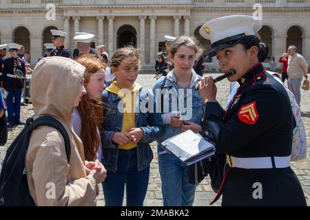 U.S. Marine Corps Cpl. Angela Guerrero, a piccolo instrumentalist with the 2d Marine Division Band plays for school kids after performing at Les Invalides in Paris, France, May 24, 2022. The purpose of their visit to Les Invalides was to perform for the disabled veterans of the French Military who were wounded in war. Stock Photo