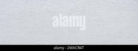 New, white painted facade with rough plaster in close-up Stock Photo