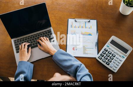 Professional business woman working on laptop computer with chart graphs and calculator Stock Photo
