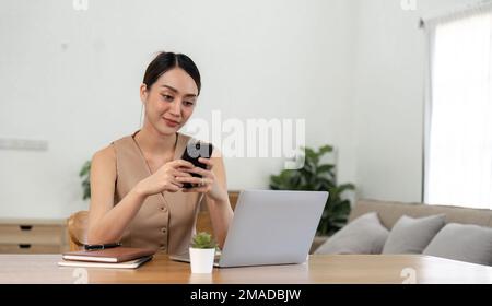 asian woman using mobile phone during checking an email or social media on internet. accounting financial concept Stock Photo