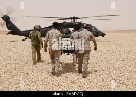 U.S. Soldiers with Task Force Hurricane from the 1st Battalion, 124th Infantry Regiment, and Royal Saudi Land Force Soldiers conduct a nine-line medical evacuation onto a U.S. Army HH-60M MedEvac Black Hawk helicopter assigned to Task Force Longhorn, at Prince Sultan Air Base, Kingdom of Saudi Arabia, May 25, 2022. Tactical combat casualty care and medical evacuation training are essential skills for the U.S. Army and our allies in order to maintain joint mission readiness and interoperability. Stock Photo