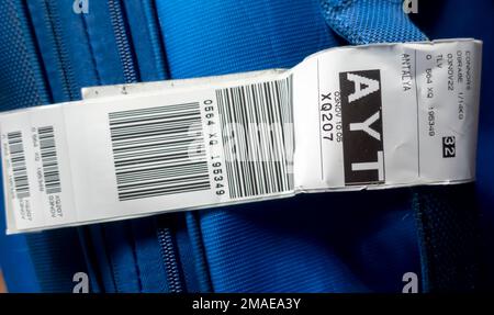 A suitcase with an airline baggage tag shows the three letter airport code for AYT - Antalya Airport Stock Photo