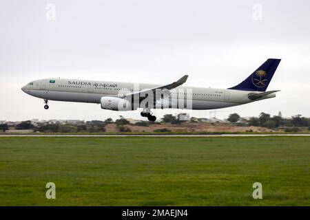 Saudia - Saudi Arabian Airlines Airbus A330-343 (REG: HZ-AQ25) arriving in light rain for servicing in Malta. Stock Photo