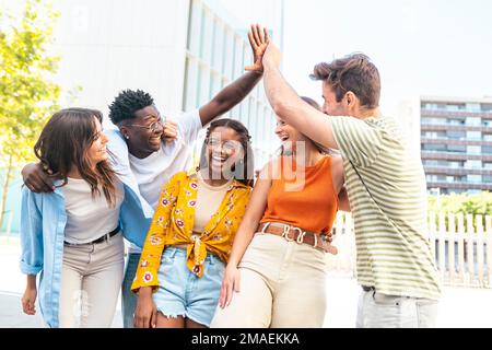 Group of happy multiracial friends having fun outdoors - Cheerful young people laughing together at city - Friendship concept. Stock Photo