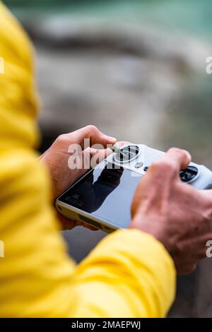 Detail of hands of caucasian man operating remote drone controller. Stock Photo