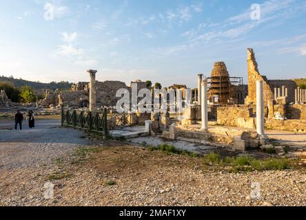 Tourists visiting the ancient city of Perge, Roman province of Pamphylia Secunda, in ruins. Antalya, Turkey Stock Photo