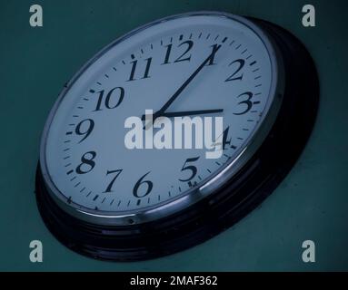 Round black and white analogue clock on the wall, 3.05 Stock Photo